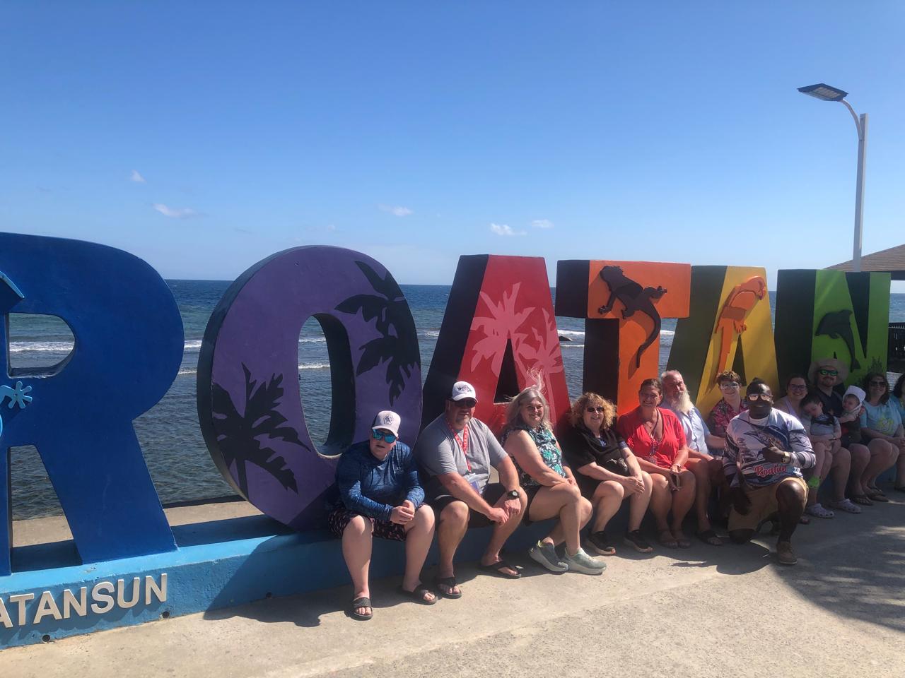 Elvis with guests at the Roatan sign